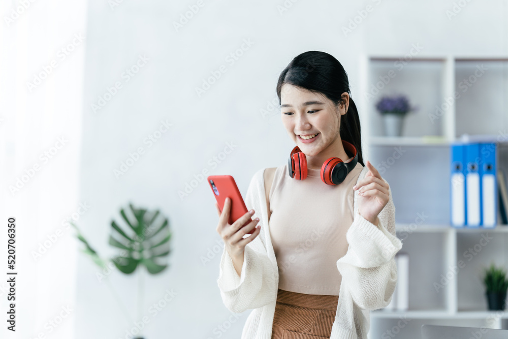 Young asian student girl smiling happy using smartphone in living room. Young asian student girl smiling happy using smartphone in living room.