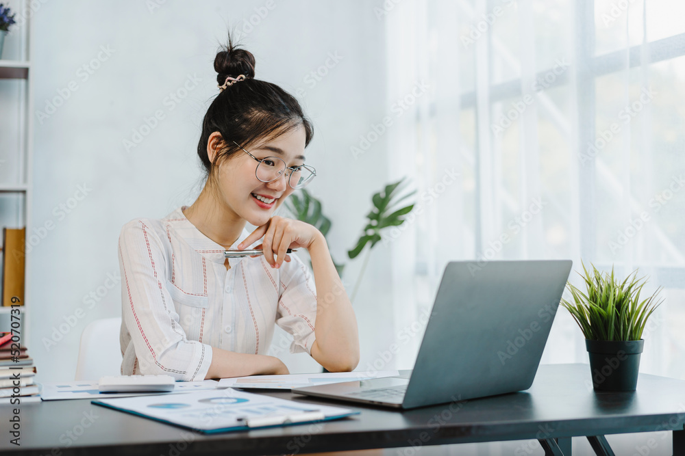 Cute asian woman feeling happy and using laptop, sitting at desk. Cute asian woman feeling happy and using laptop, sitting at desk.