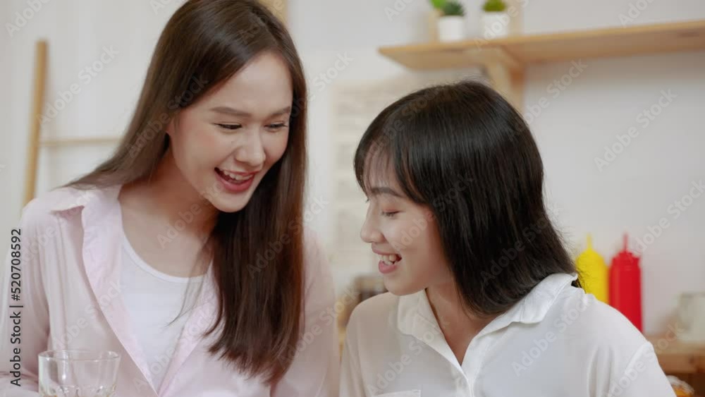 friend or lesbian couple is serving each other orange juice. friend or lesbian couple is serving each other orange juice.
