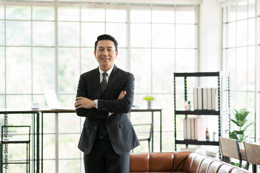 Asian, adult businessman and office. Portrait of Asian business man wear suit at the office. Smiling Asian business man standing with background modern office Asian, adult businessman and office. Portrait of Asian business man wear suit at the office. Smiling Asian business man standing with background modern office