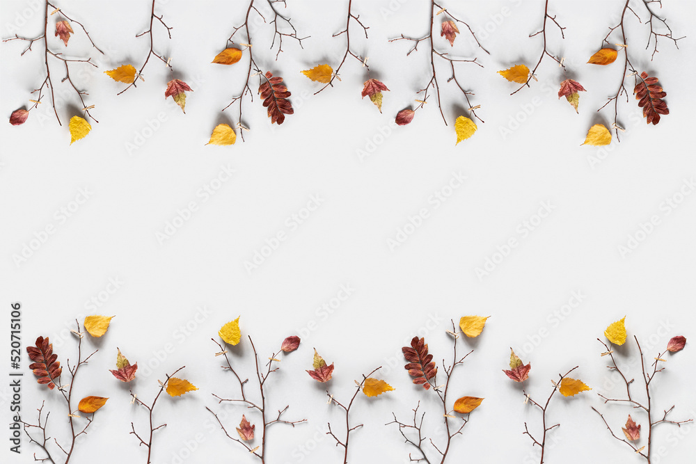 Creative autumn frame. Branches of trees with colorful autumn leaves on clothespins on gray background with copy space. Top view, Flat lay
