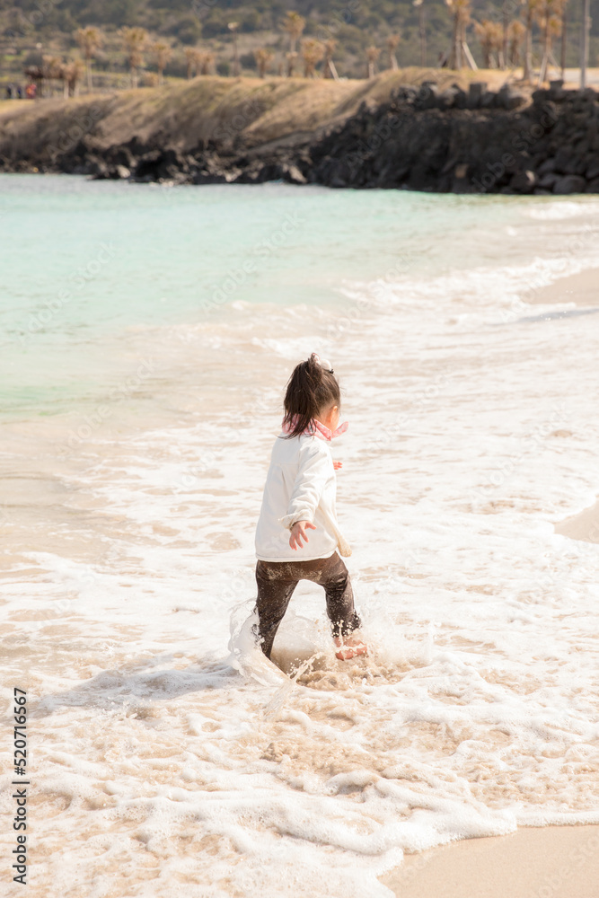 a child playing on a surfy beach