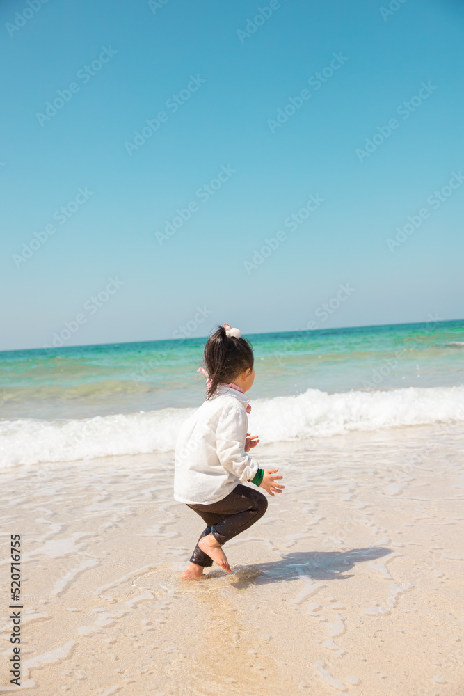a child playing on a surfy beach a child playing on a surfy beach