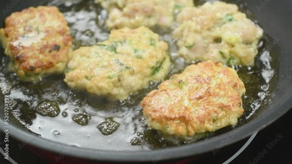 The cook turns the chicken fritters with cheese into the frying pan with a spatula.
The cook turns the chicken fritters with cheese into the frying pan with a spatula.