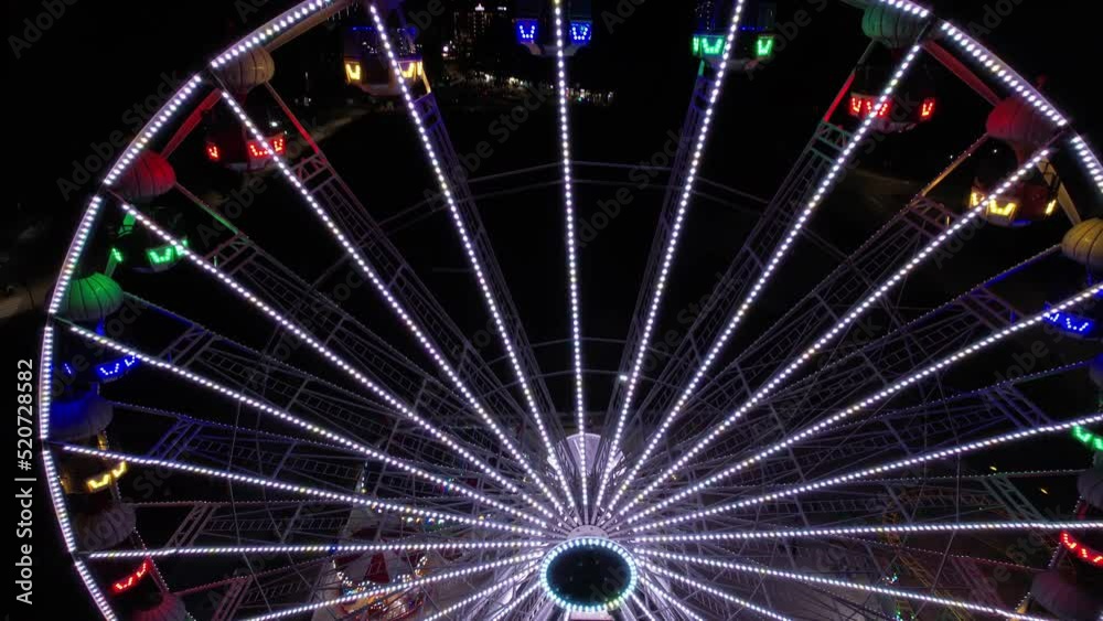 Aerial View of Colorful Ferris Wheel Lights at Night, Illuminated Tourist Attraction Aerial View of Colorful Ferris Wheel Lights at Night, Illuminated Tourist Attraction