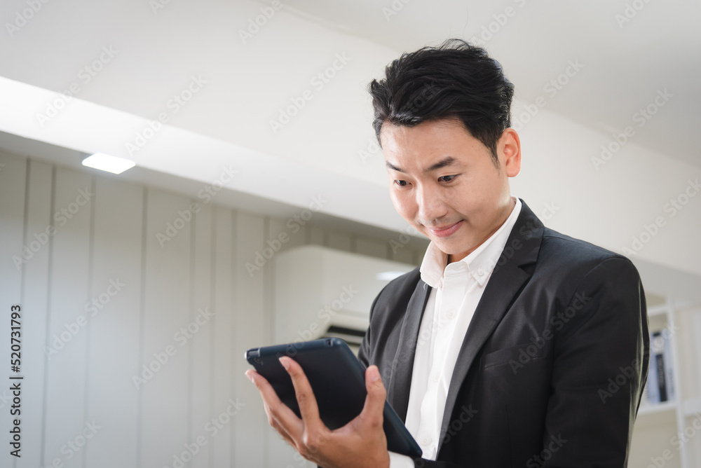 Young business Asian man using tablet for working with confident and focus in modern workplace. Young business Asian man using tablet for working with confident and focus in modern workplace.