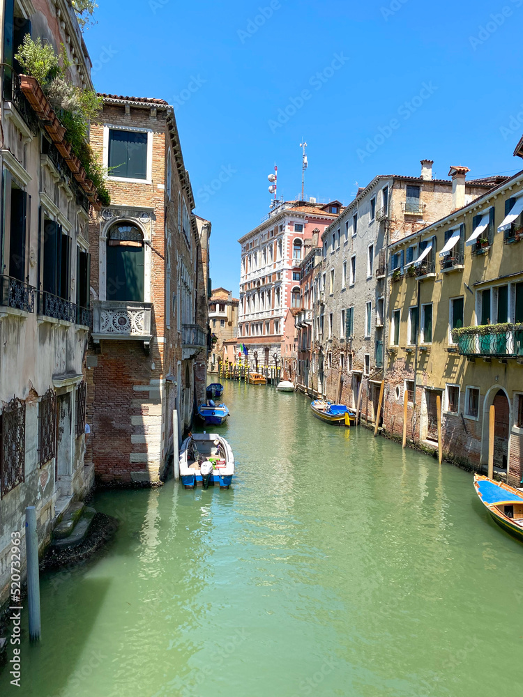The view of the calm canal with boats, Venice, Italy