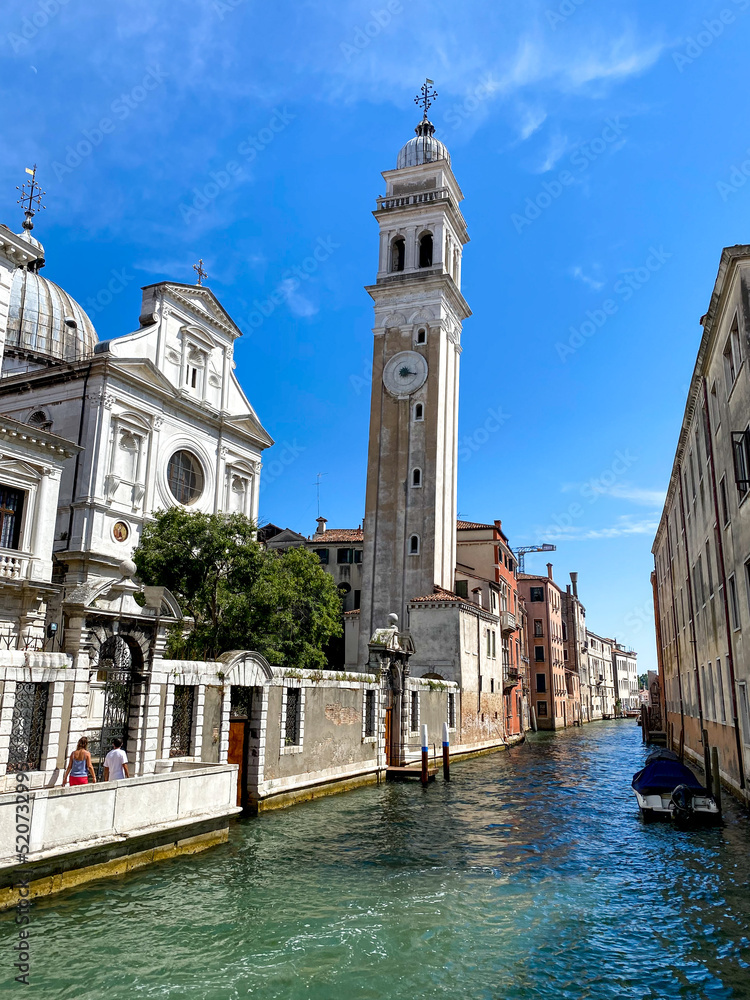 The view of the calm narrow canal with chapel and cathedral, Venice, Italy