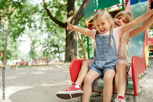 Konstfotografi Two cute girls have fun at playground in sunny day