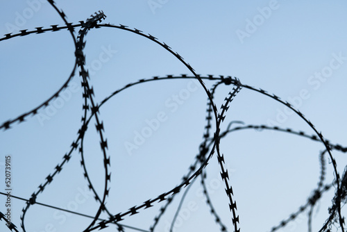 Fence with barbed wire defending against refugees with copy space.