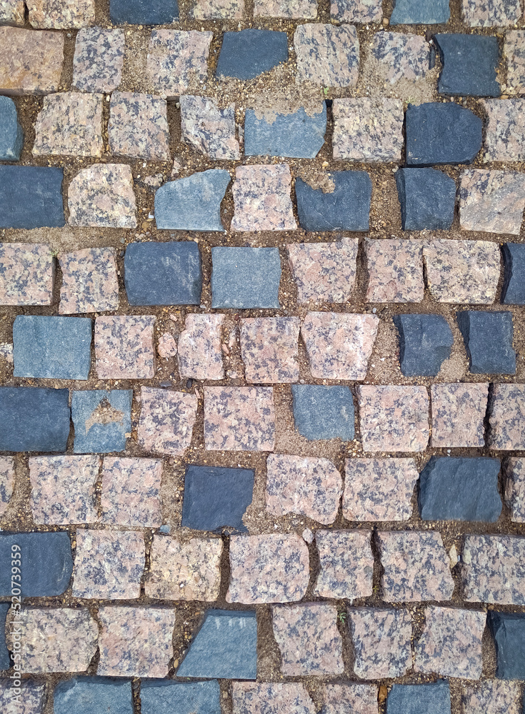 Old road pavement with granite stones. Paving stones. Old road pavement with granite stones. Paving stones.