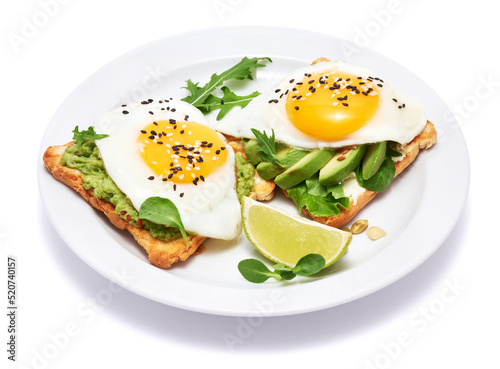 sliced avocado and fried egg on toasted bread isolated on white background