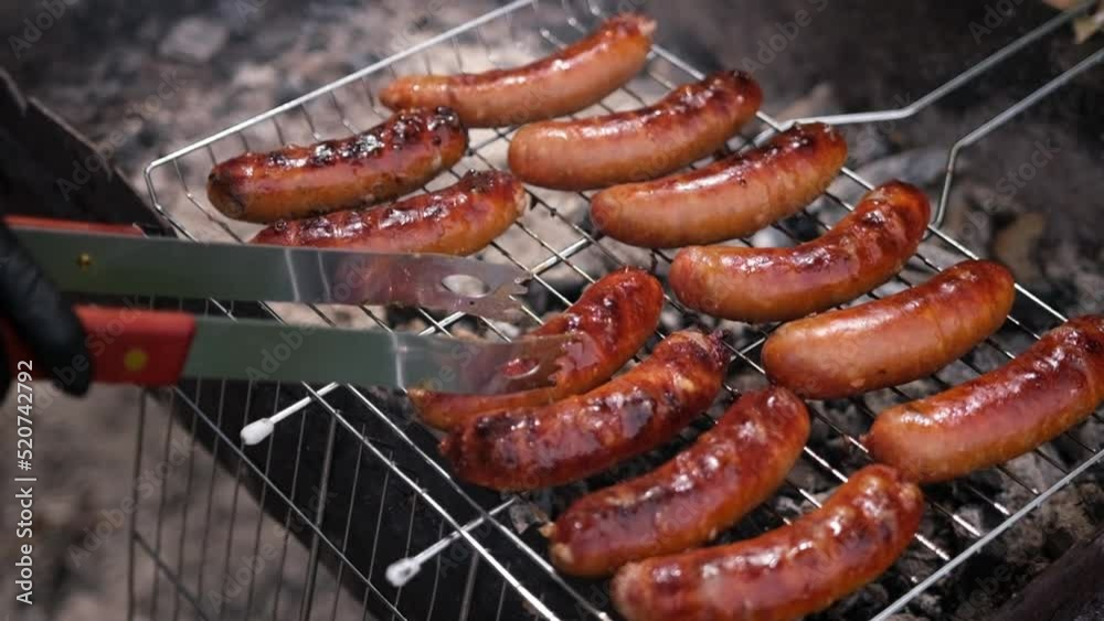 close-up view of tasty sausages grilling on charcoal grill grate