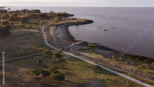 Aerial view of Vicente Lopez coastal park with many people and tranquil water of Atlantic Ocean at sunset  - Panorama wide shot photo