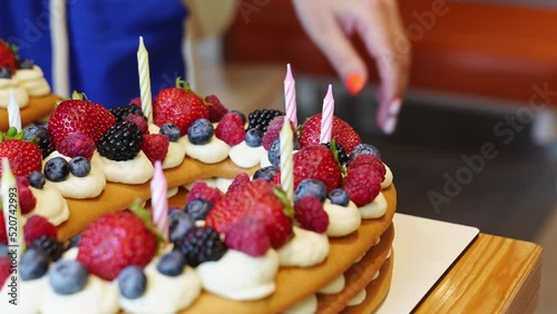 candles put on the cake with berries in the form of the number ten. photo