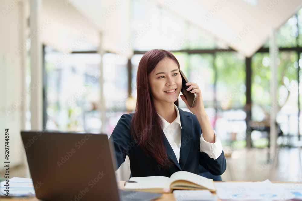 Asian businesswoman using the phone to contact a business partner