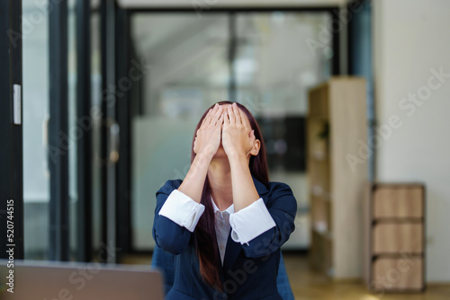 Portrait of an Asian businesswoman showing a headache from depression