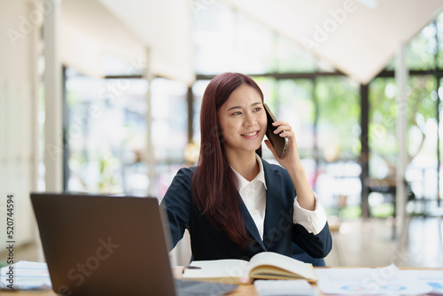 Asian businesswoman using the phone to contact a business partner