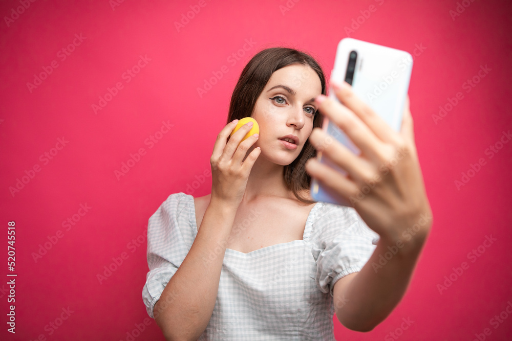 Beauty blogger recording makeup tutorial on pink background Beauty blogger recording makeup tutorial on pink background