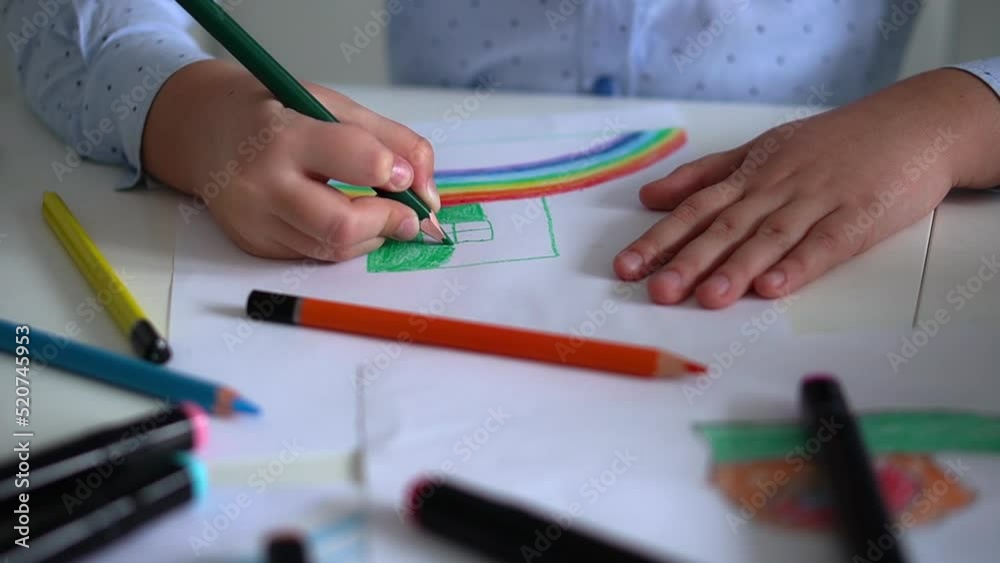Kids creativity. Child little girl drawing rainbow with colored pencils on paper at home Kids creativity. Child little girl drawing rainbow with colored pencils on paper at home