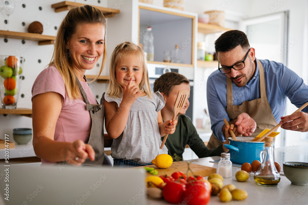 Happy family preparing healthy food together in kitchen Happy family preparing healthy food together in kitchen