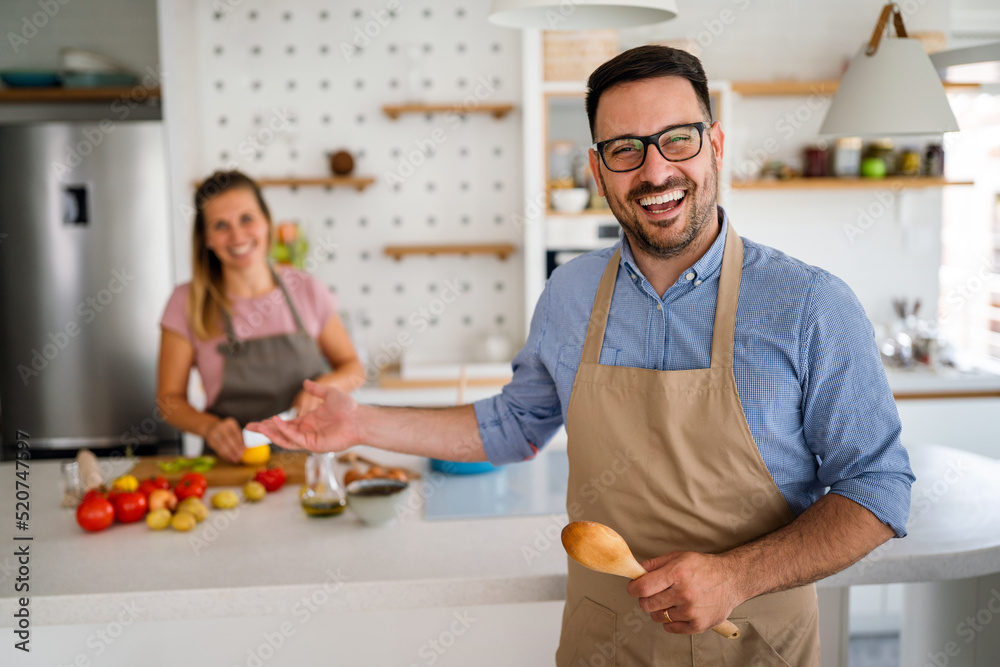 Young happy couple is enjoying and preparing healthy meal in their kitchen together Young happy couple is enjoying and preparing healthy meal in their kitchen together