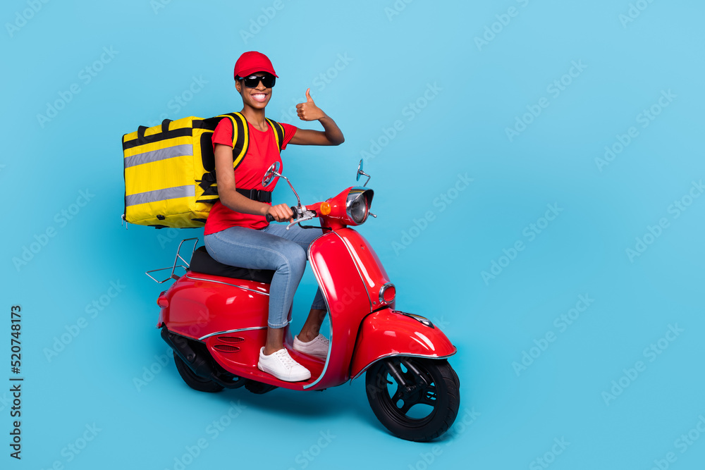 Full size photo of positive person ride moped show thumb up advice recommend isolated on blue color background Full size photo of positive person ride moped show thumb up advice recommend isolated on blue color background