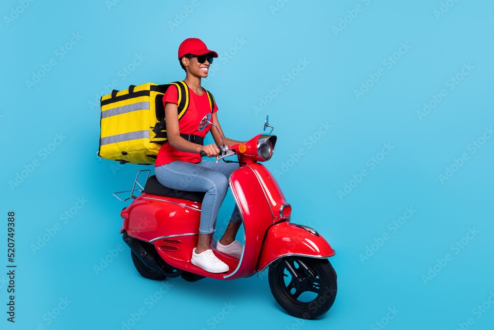 Photo of funny busy short hair person dressed red uniform moto rider delivering food isolated blue color background Photo of funny busy short hair person dressed red uniform moto rider delivering food isolated blue color background