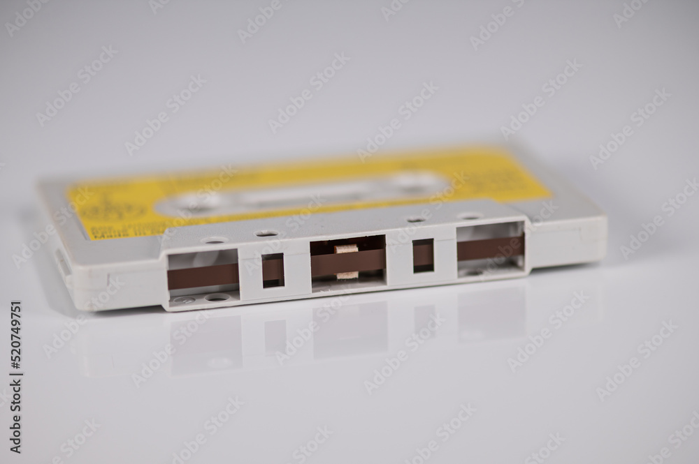 Music cassette with yellow label lying on a light background Music cassette with yellow label lying on a light background