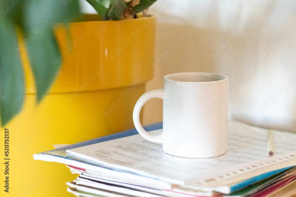 A white mug on a stack of papers