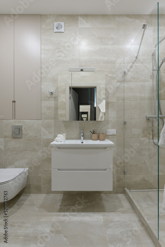 modern bathroom interior, bathroom with beige tile with stone texture