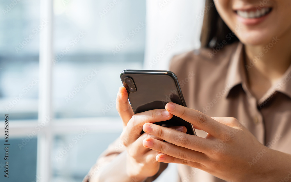 Smiling young woman hand holding smartphone with using social media on internet. Smiling young woman hand holding smartphone with using social media on internet.
