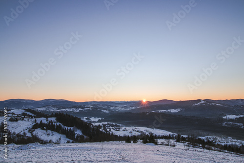 Morning sun from Mount Ochodzita in Beskydy Mountains in Slovakia on a frosty morning with a view of low and high Tatras in Poland and Slovakia