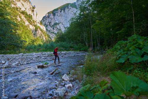 Woman hiker crossing river
