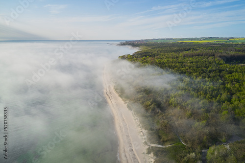 fog over the ocean hitting the shore in denmark photo