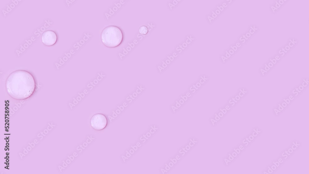round drops of transparent gel serum on pink background round drops of transparent gel serum on pink background