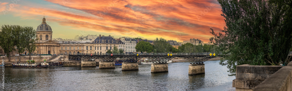 Panoramic view of the Pont des Arts in Paris with a beautiful sky at sunset and over a beautiful Seine river that divides the Parisian city in two creating a beautiful contrast and beautiful scenery.