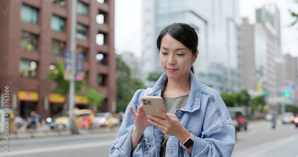 Obraz premium Woman walk in the street with look at the cellphone