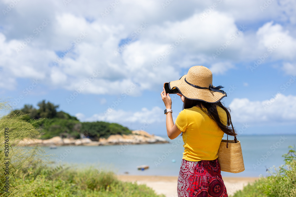 Woman use take photo on mobile phone in seaside