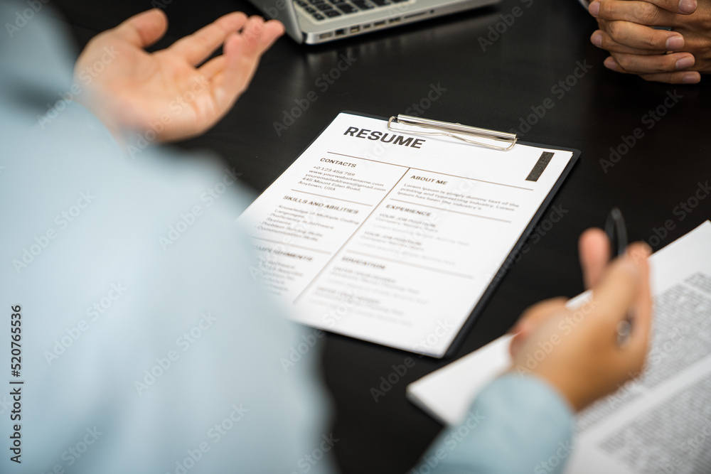 Examiner reading a resume during job interview at office Business and human resources concept. Examiner reading a resume during job interview at office Business and human resources concept.