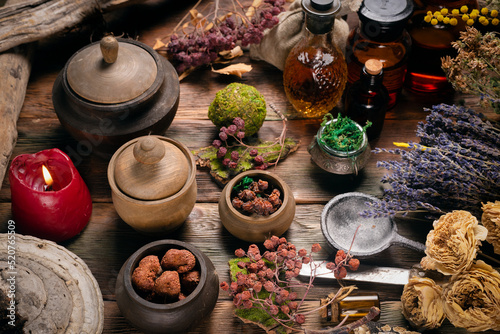 Herbal medicine concept background. Dry natural ingredients and remedy bottle on the wooden table background. Top view.