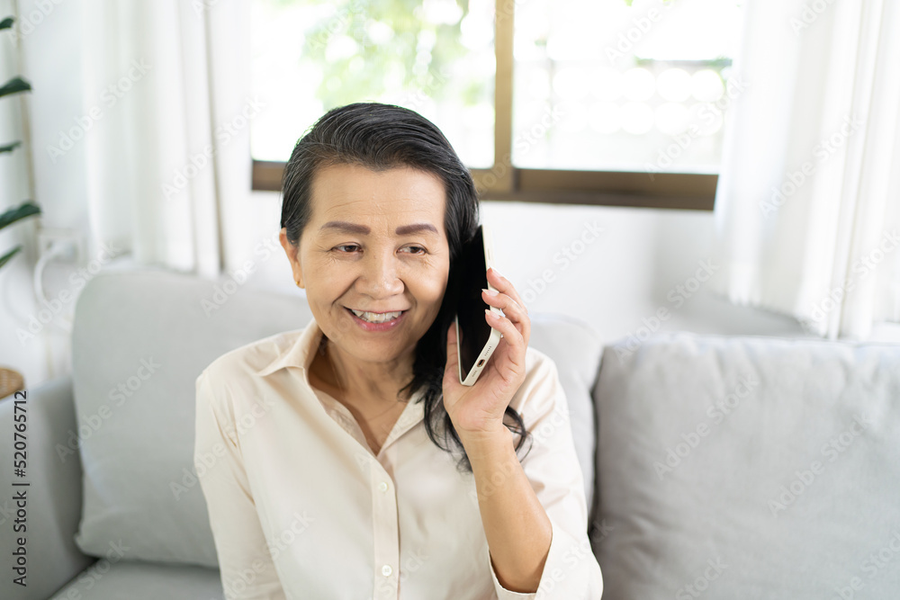 Middle age Asian woman holding cell telephone . smiling Beautiful mature asian woman talking on the smart phone with technology concept Middle age Asian woman holding cell telephone . smiling Beautiful mature asian woman talking on the smart phone with technology concept