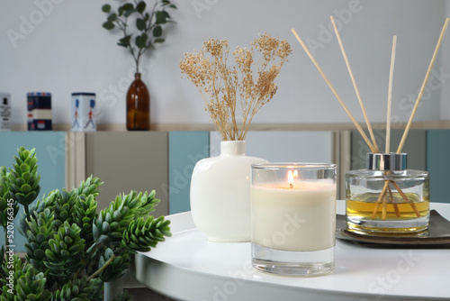 Foto luxury lighting aromatic scented candle is on white metal table with ceramic vas
