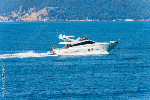White luxury yacht or speedboat in motion on Mediterranean sea in front of the Palmaria island, Porto Venere or Portovenere, Gulf of La Spezia, La Spezia, Liguria, Italy, Europe. © Alberto Masnovo