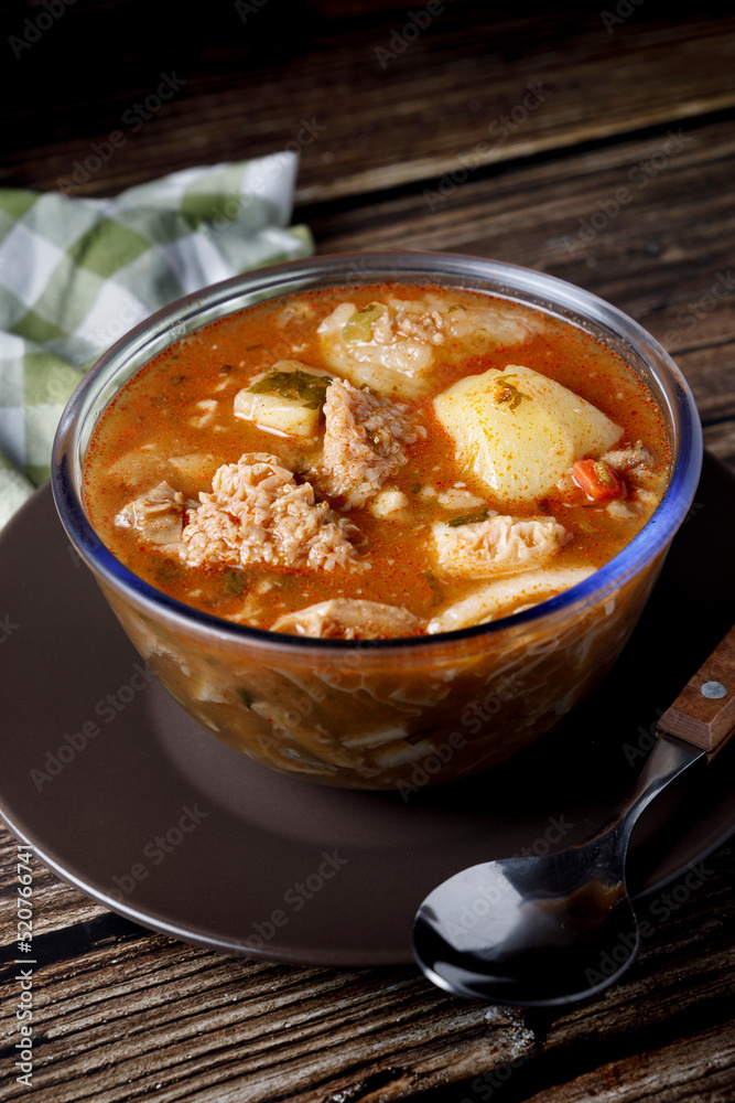 Colombian traditional tripe soup in a glass bowl on wooden table