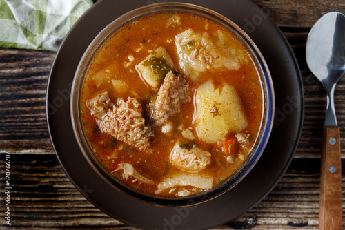 Colombian traditional tripe soup in a glass bowl on wooden table