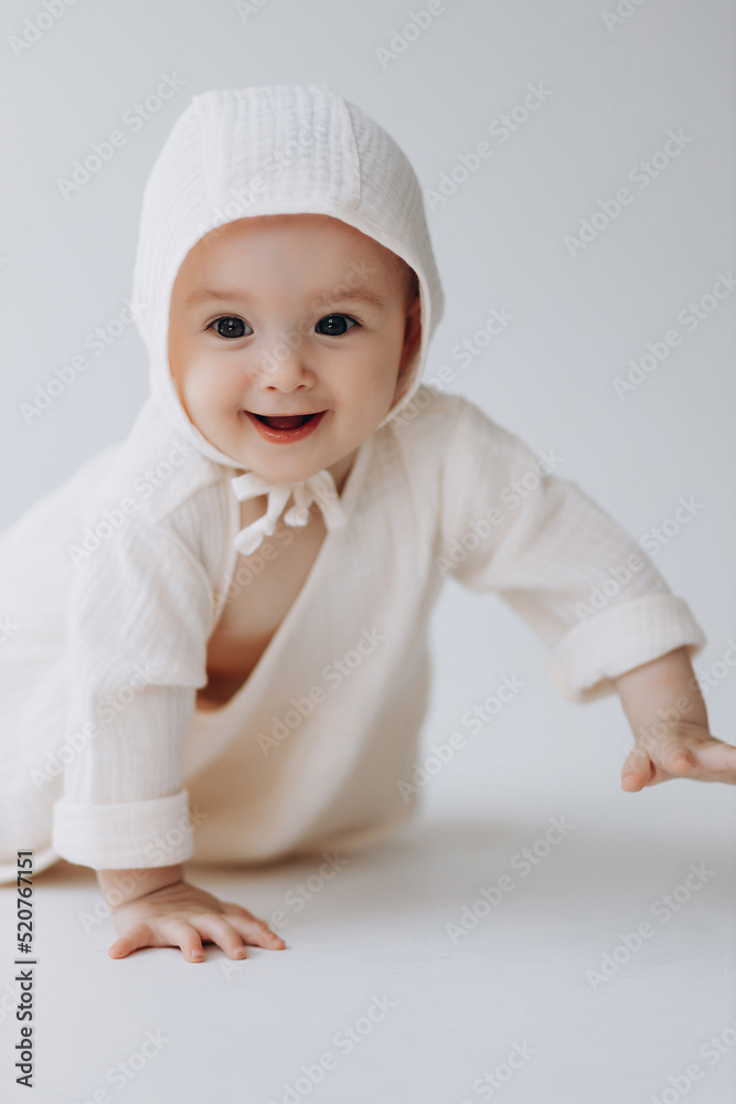Cute studio portrait of a little newborn which has already begun to crawl. The child laughs and rejoices in his first little steps Cute studio portrait of a little newborn which has already begun to crawl. The child laughs and rejoices in his first little steps