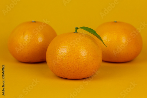 Group of three juicy orange isolated on yellow background. and Healthy oranges used in orange juice drnking concept design photo