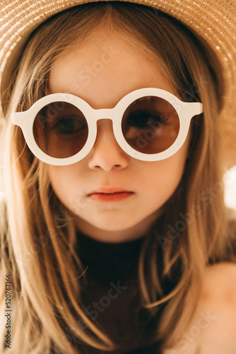 stylish studio portrait of a little girl in white-rimmed glasses