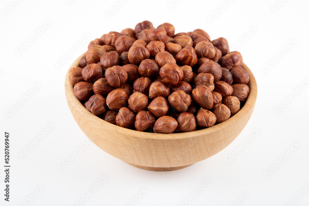 Bowl full of hazelnuts on white background Bowl full of hazelnuts on white background